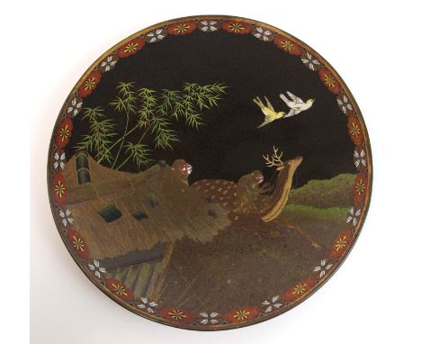 A cloisonne enamel plaque decorated with a monkey riding a deer, another on a roof top and with a pair of doves before bamboo