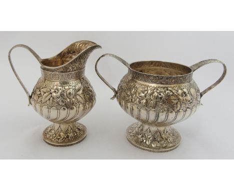 A silver cream and sugar by Tiffany & Co., marked 4494M6323 Sterling silver, of bulbous baluster shape, the body's lower half