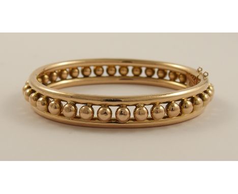 A 15ct rose gold Early 20th century bangle with ball detail to both sides, approx weight 14.6gms, internal largest diameter 5