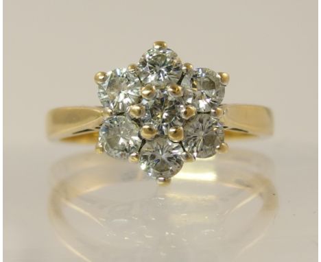 An 18ct gold diamond flower ring of approximately 1.12cts combined, in 18ct yellow and white metal with tapering tubed shank,