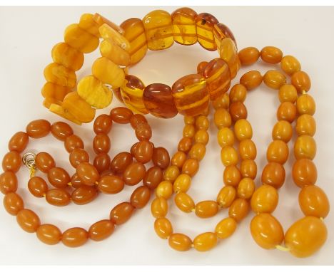 A collection of amber coloured beads and bracelets a long butterscotch amber coloured bead necklace, largest bead 21mm x 16.6
