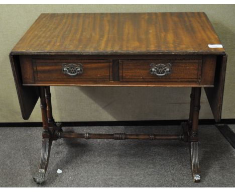 A mahogany small drop leaf sofa table with two drawers, on turned feet and with cross-stretcher and paw casters, 49.5m high x