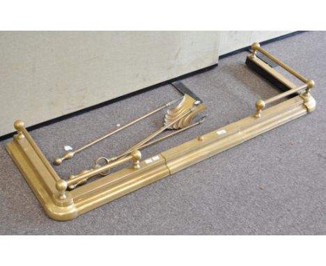 A large brass fender and four fire tools, the fender with gallery, 134cm wide