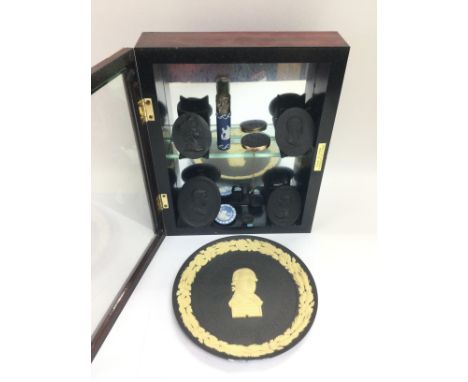 A small display cabinet containing various Wedgwood jasperware and black basalt portrait miniatures.