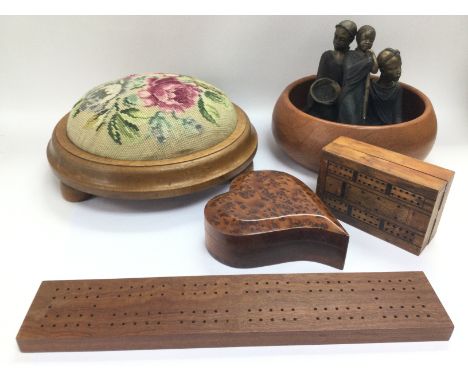 A collection of treen comprising a jewellery box, cribbage boards, a footstool with a cross stitch top etc.