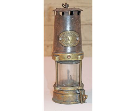 A miner's safety lamp, height 24.5cm. CONDITION REPORT - generally a little dented and misshapen, wear throughout.
