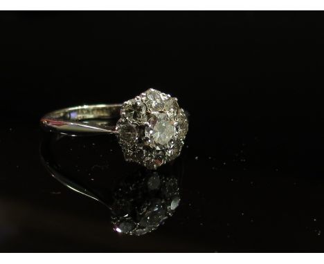 WITHDRAWN - An 18ct gold platinum set diamond daisy ring, central stone 0.25ct approx., size K/L, 2.7g