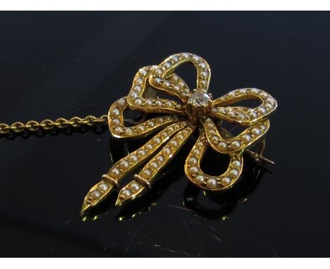 A gold triple bow brooch with diamond centre encrusted with seed pearls, with safety chain, 9.2g