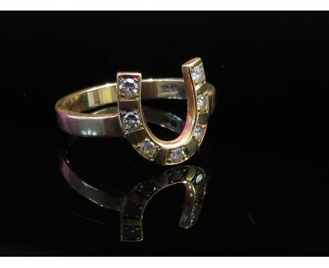 An 18ct gold "horseshoe" ring set with seven brilliant cut diamonds, size V, 5.8g