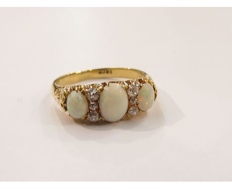 An 18ct gold three stone opal and diamond ring, size N, 4.7g