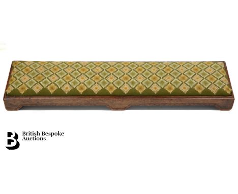 A large footstool with embroidered upholstery, approx 110 cms in length.&nbsp;