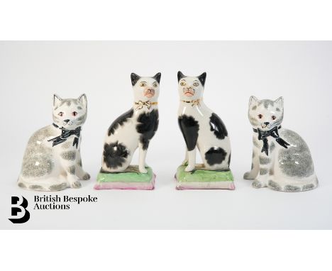 Pair of Staffordshire pottery cat ornaments, left and right facing, depicted seated on green cushions, both cats are black an