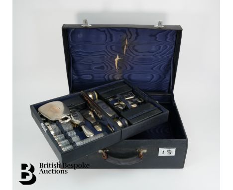 An Art Deco glass and sterling silver travelling vanity set, the navy blue suit case opens to reveal a tray of vanity impleme