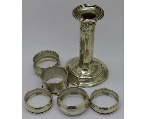 Five silver napkin rings including one pair and a silver candlestick, candlestick a/f