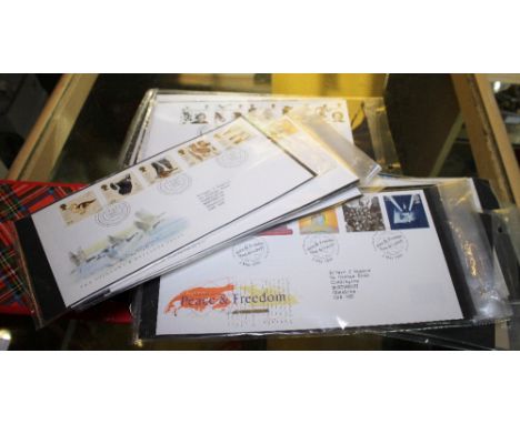 FIRST DAY COVERS. Four albums of first day cover postage stamps including some mint. approximately 200.