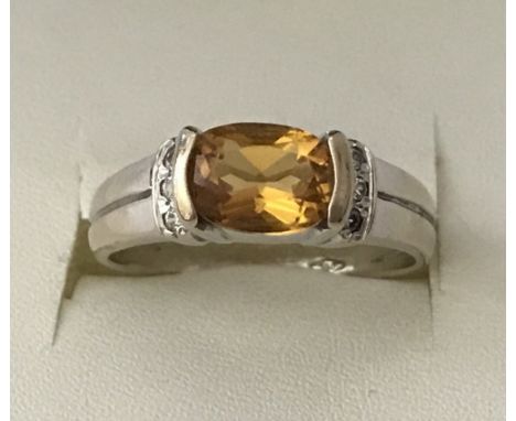 An 18ct gold citrine and clear stone ladies dress ring. Central oval cut citrine with 3 small clear stones to either side. Si