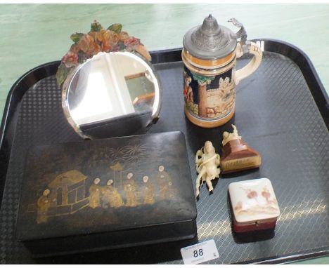 A small bevel glass toilet mirror with plaster flower decoration, a Japanese lacquer games box, a small stein, a small porcel