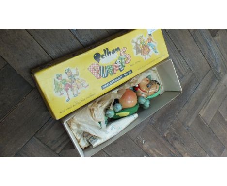 A boxed Pelham puppet of a baby dragon