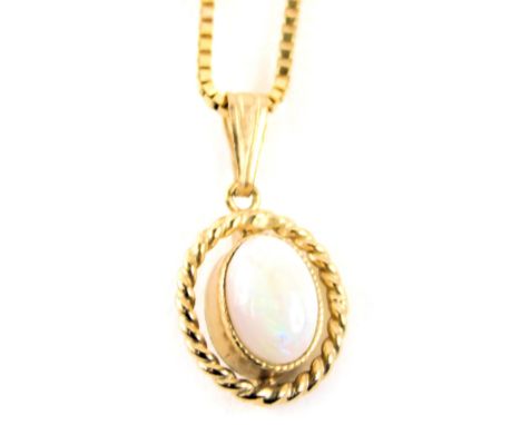 A 9ct gold opal pendant and chain, the oval opal with rope twist border, 1.5cm wide, on a fine link neck chain, 44cm long, 2.