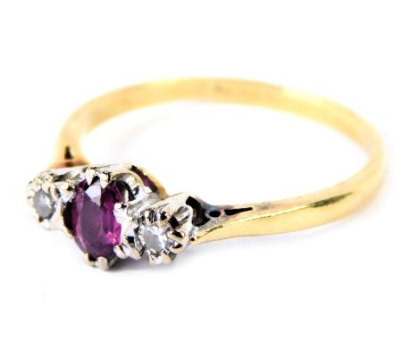 An 18ct gold ruby and diamond three stone dress ring, with central oval ruby in eight claw setting, flanked by two tiny diamo