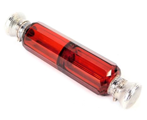 A Victorian cranberry glass double ended scent bottle, the white metal ends with engine engraved floral decoration, white met