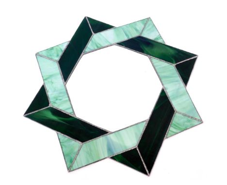 A green glass wall mirror, of star design with emerald and light green panels, 60cm diameter. 