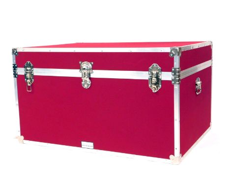 A large cabin type trunk by The Storage Trunk Company, with alloy metal framework and two carrying handles, in magenta cloth,