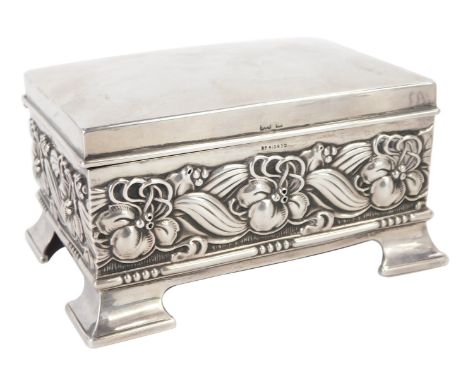 An Edward VII silver playing card box, embossed with a band of flowers and scrolling leaves, raised on bracket feet, with a r