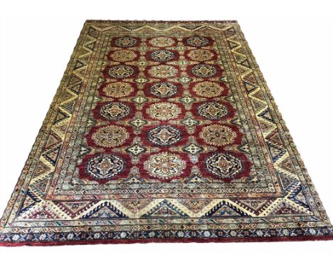 FINE KAZAK CARPET, 371cm x 246cm, rows of geometric medallions on a ruby field within multiple complimentary borders.