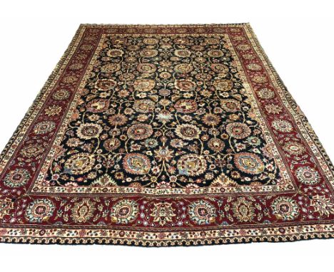 TABRIZ DESIGN CARPET, 345cm x 262cm, all over palmettes and scrolling vines, on an emerald field within multiple correspondin