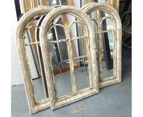 ARCHITECTURAL MIRRORS, a set of three, domed top in a distressed, painted finish, 94cm x 56cm. (3)