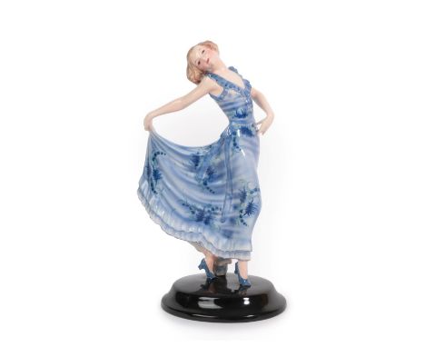 An Art Deco Goldscheider Model of a Dancer, designed by Josef Lorenzl, modelled as a young woman wearing a blue floral dress,