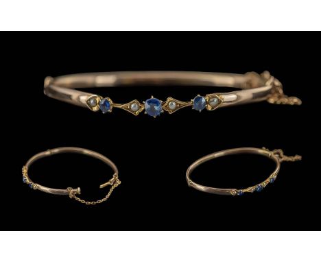 Ladies Pleasing 9ct Gold Hinged Bangle Set with Sapphires and Seed Pearls, with safety chain, of elegant form; weight 4.6g