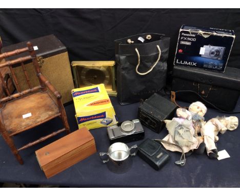 A collection of vintage cameras, slides in a carrying case, small wooden chair with Grandma dolls.