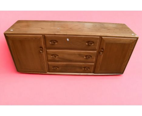 A 1970s light oak Ercol sideboard.