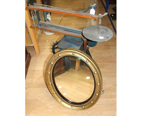A vintage hobbies cast cutting machine along with a gilt oval wall hanging mirror.