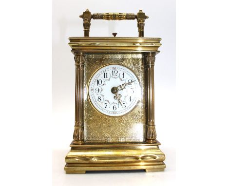 A 20th century brass cased large carriage clock, foliate designed dial with enamelled face, columned supports and carry handl