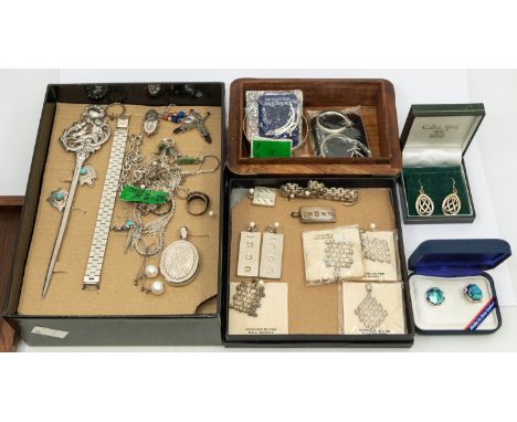 A collection of silver jewellery including a Victorian engraved buckle bangle, oval lockets, together with various chains in 