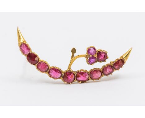A ruby and gold crescent brooch, set with oval mixed cut rubies, with smaller round mixed cut rubies, length approx 35mm, pos