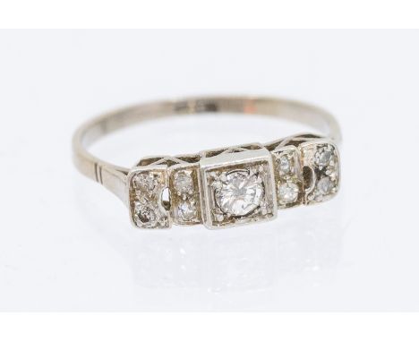 A 1930's diamond set 18ct gold ring, comprising a stepped mount, set with a central diamond, with grain set diamond shoulders