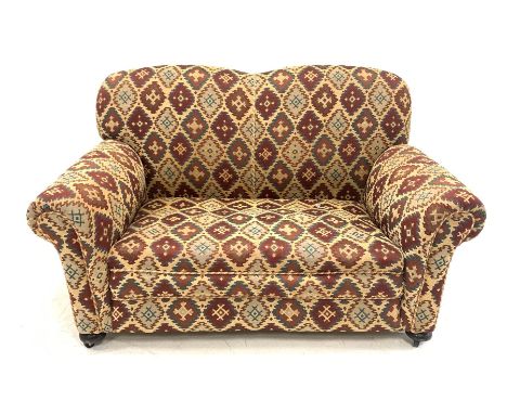 Early 20th century two seat sofa, upholstered in kilim type fabric raised on turned front supports with recessed castors (W14