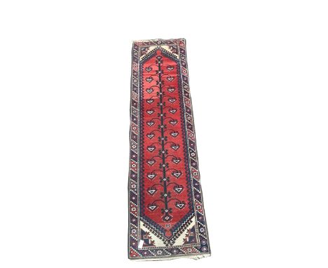 Caucasian design runner, red field with black and blue geometric design, enclosed by border 76cm x 183cm
