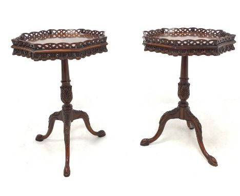 Pair of Georgian style mahogany lamp tables, octagonal pierced fretwork tray tops over carved aprons and leaf carved columns,