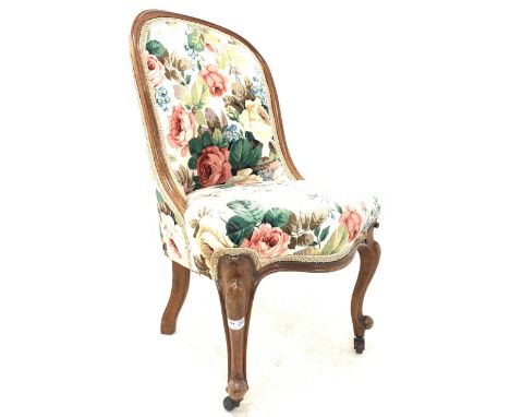 Victorian rosewood nursing chair, moulded frame and upholstered in floral linen, raised on scroll carved cabriole supports an