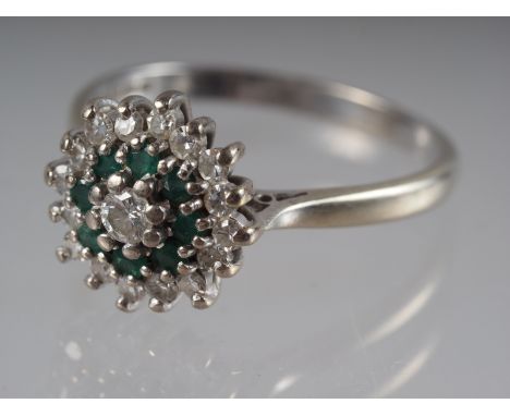 An 18ct white gold dress ring cluster set emeralds and diamonds, 4.4g gross, size R 