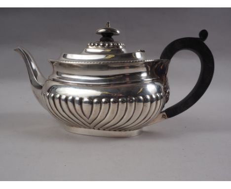 A silver half-fluted teapot with composition handle, 22.2oz troy gross 