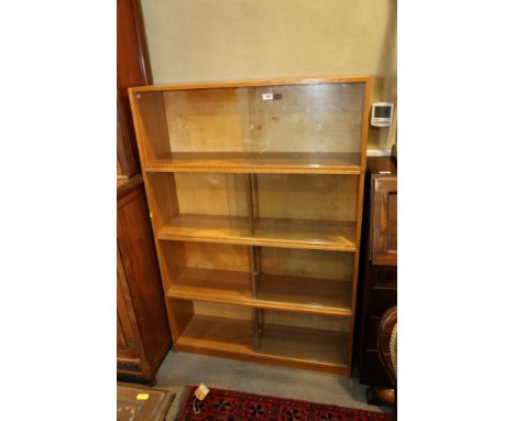 A light oak sectional bookcase enclosed four pairs of sliding glass doors, on block base, 36" wide x 10 1/2" deep x 53" high 
