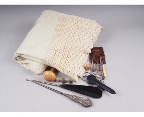 An assortment of sewing accessories, including button hooks, thimbles, scissors and other items, including a bedspread 