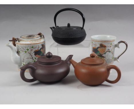 An Japanese black cast iron teapot, two stoneware teapots and a porcelain teapot with matching mug 