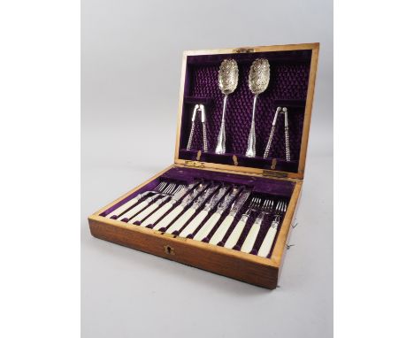 A set of silver plated engraved fruit knives and forks, in oak fitted case, serving spoons and a nut cracker 